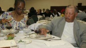 Greater Piney Grove Baptist Church members learn the ritual of placing a drop of wine for each plague. 